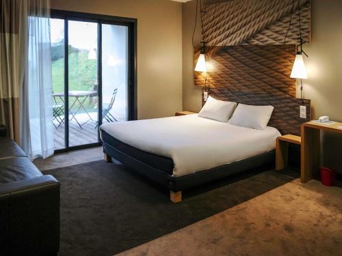 une chambre d'hôtel avec un lit et un balcon dans l'établissement ibis Saint-Malo Madeleine, à Saint-Malo