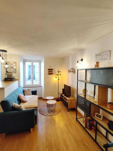 un salon avec un canapé bleu et une télévision dans l'établissement Le Nomézia, à Ax-les-Thermes