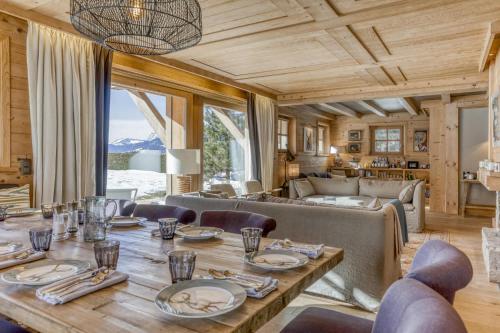 une salle à manger avec une table et un canapé dans l'établissement Chalet Glisse, à Megève