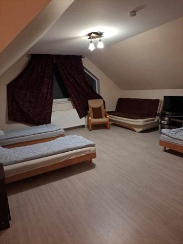 a large room with two beds and a chair at Agroturystyka Biełka in Giełczyn