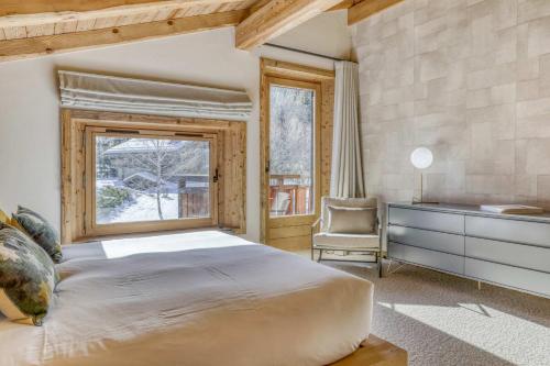 une chambre avec un grand lit et un bureau et une fenêtre dans l'établissement Chalet Alpina, à Megève