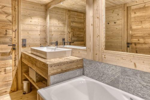 une salle de bain avec une baignoire et un lavabo dans l'établissement Chalet Alpina, à Megève