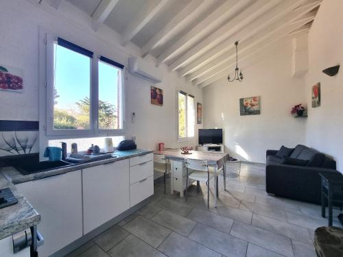 Il comprend une cuisine et un salon avec une table. dans l'établissement Maison bord de mer climatisée avec jardin, parking et WiFi à Port-Vendres - FR-1-309-7, à Port-Vendres
