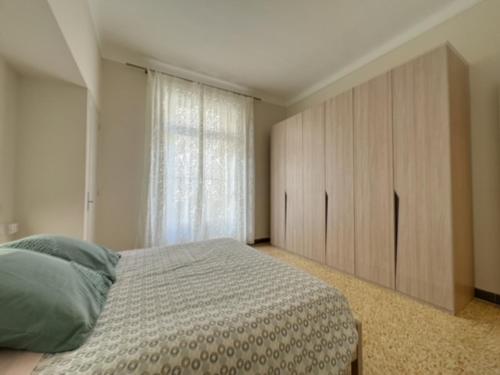 une chambre avec un lit et une grande fenêtre dans l'établissement Appartement central rue Hoche, à Cannes