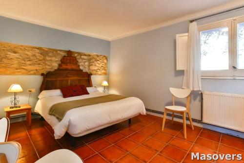 a bedroom with a large bed in a room at MAS DE BERNIS - Masia in L'Aldea