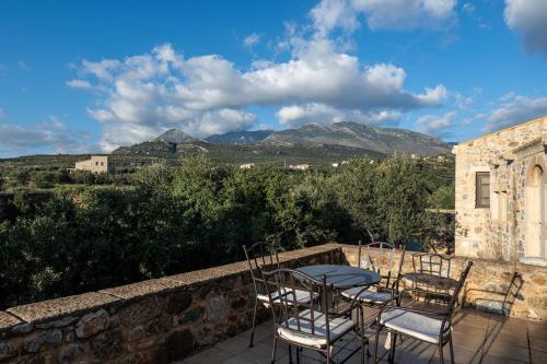 a table and chairs on a patio with mountains at Tzokeika Traditional Settlement in Riglia