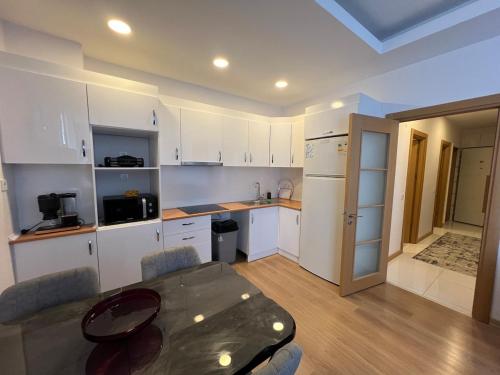 una cucina con mobili bianchi e un tavolo con sedie di Luxury Designed Comfortable 2 Rooms & 1 Living room Apartment Free Parking Garaj a Esenyurt