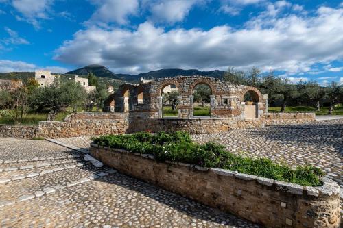 an old stone building with an arch in a courtyard at Tzokeika Traditional Settlement in Riglia