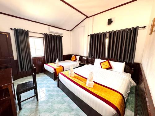 a hotel room with two beds and a window at Jungle Backpackers View in Vang Vieng
