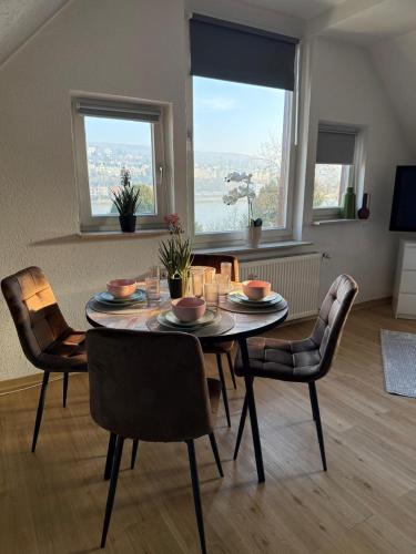 a dining room with a table and chairs with a view at Schickes Apartment am Rhein in Koblenz