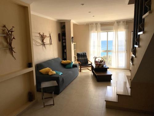 a living room with a blue couch and a window at Appartamento Sinestesia Oceanica in Puerto del Rosario