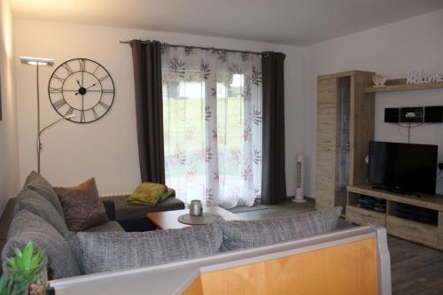 a living room with a couch and a large window at Ferienhaus Nr 49, Kategorie Premium, Feriendorf Hochbergle, Allgäu in Lechbruck