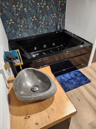 un évier en métal assis au-dessus d'une table en bois dans l'établissement Love room La parenthèse enchantée, à Pia