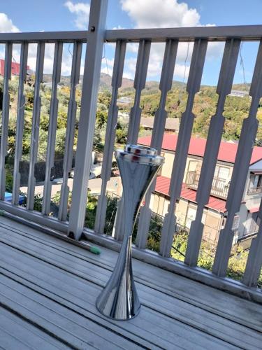 a metal vase sitting on a wooden deck at 個室201セミダブル1台駅徒歩6分Atami Hakoneも近いゲストハウス真鶴 in Manazuru