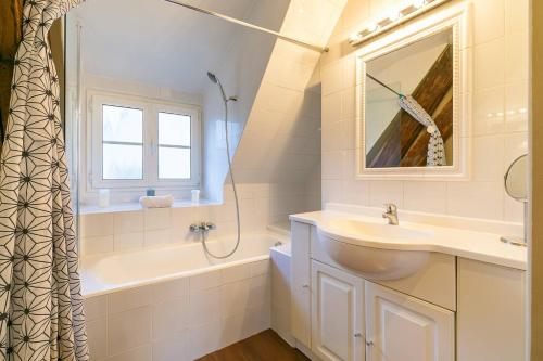 a bathroom with a sink and a tub and a mirror at LA Plume aux pieds du Parvis Saint Jean in Dijon