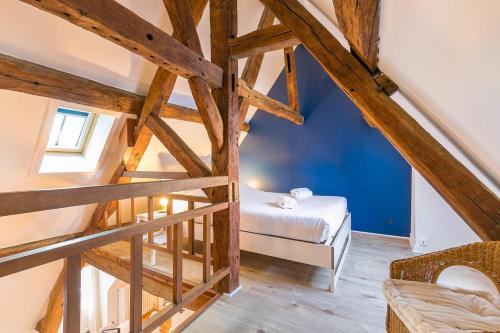 a attic room with a bed and a staircase at LA Plume aux pieds du Parvis Saint Jean in Dijon