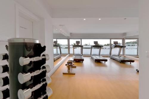 a gym with several treadmills in a room with windows at Airotel Galaxy in Kavala