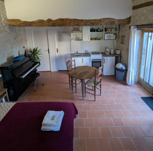 un salon avec une table et une cuisine dans l'établissement Le Sabathe, à Saint-Mézard