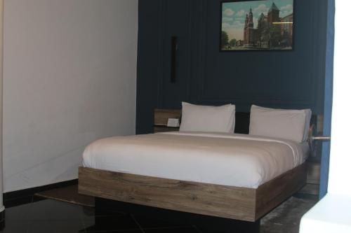 a bed with white sheets and pillows in a room at The Hotel Syracuse in Casablanca