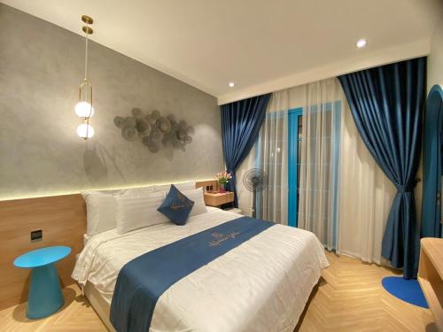- une chambre avec un grand lit et des rideaux bleus dans l'établissement HT Sea Villa - 7 Bed Rooms, à Hạ Long