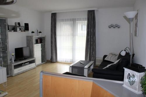 a living room with a couch and a tv at Ferienhaus Nr 50, Kategorie Premium, Feriendorf Hochbergle, Allgäu in Lechbruck