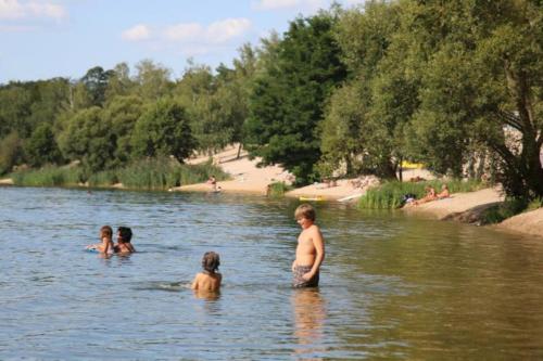 a group of people swimming in a river at HELSINKI - Studio mit Sandstrand & Seeblick nahe Rhein-Main und Spessart in Kahl am Main