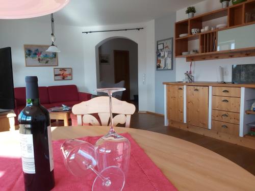 a bottle of wine and a glass on a table at HOME4GOLF Uttlau in Bad Griesbach