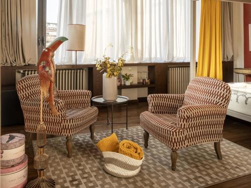 a living room with two chairs and a table at Canto degli Scali in Florence