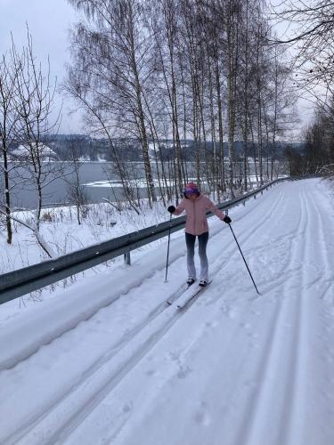 a woman is cross country skiing on a snow covered road at Winnica Spisz in Łapsze Niżne