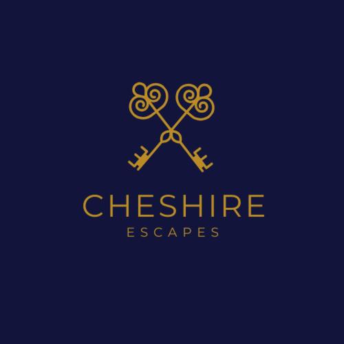 a gold logo with a pair of scissors at Stylish Stay Near To Carden Park By Cheshire Escapes in Malpas