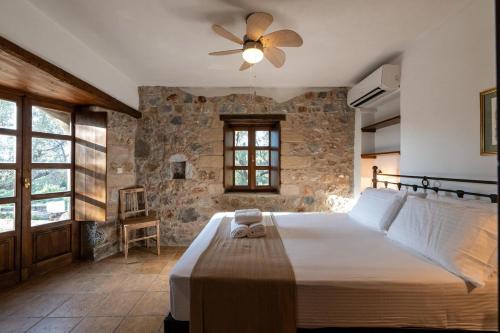 a bedroom with a large bed with a ceiling fan at Tzokeika Traditional Settlement in Riglia