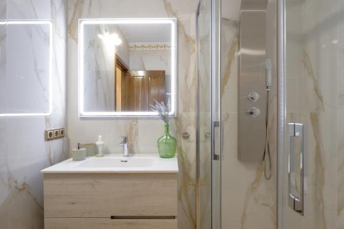 a bathroom with a sink and a shower with a mirror at Palacio de la Canaliega in El Rocío