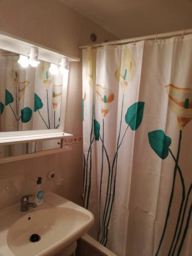 a bathroom with a shower curtain with flowers on it at Bitacora I Solo Familias Serviplaya!!! in Playa de Xeraco