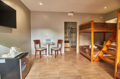 a room with a bunk bed and a table and chairs at Mactan Resort by 1521 in Mactan
