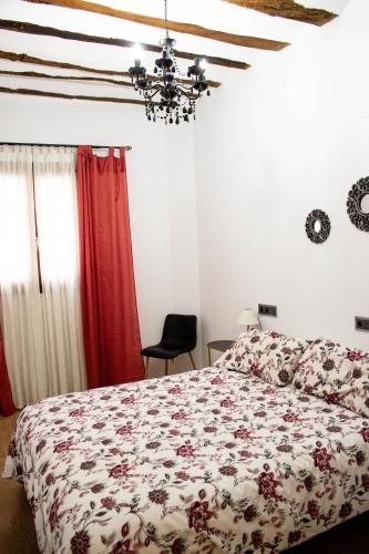 a bedroom with a bed with a floral bedspread at Apartamentos de Don Juan in Úbeda