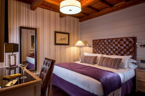a bedroom with a bed and a table and a mirror at The Inn at the Spanish Steps Luxury Collection - The Inn at the Spanish Steps in Rome