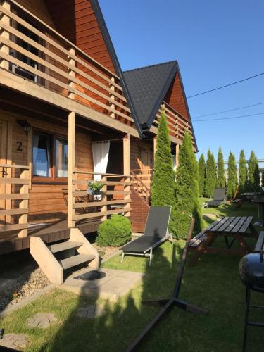 a house with a table and a laptop in the yard at Domki z sauną Bieszczady Boso po Rosie in Polańczyk