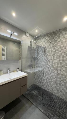 une salle de bain avec un lavabo et une douche en verre dans l'établissement 90m2 Apartement - Les Palmiers de Cannes, à Cannes