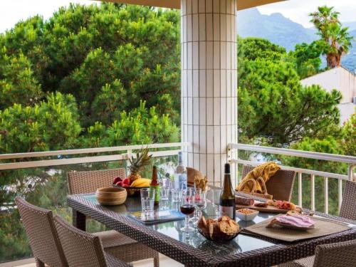 - une table avec de la nourriture et du vin sur le balcon dans l'établissement Apartment MB6 sans vue mer by Interhome, à Moriani-Plage