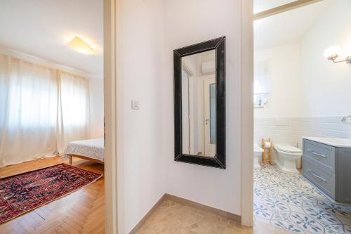 Un baño con un lavabo y un espejo en la pared. en Li dell'Ospedale, en Udine