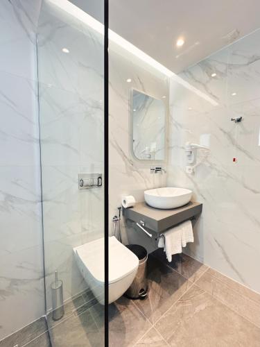 biała łazienka z toaletą i umywalką w obiekcie Hotel Nerium w mieście Ksamil