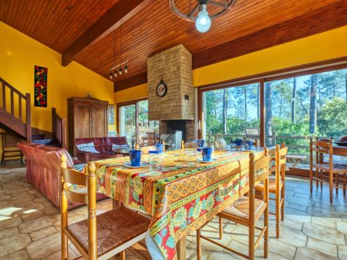 une salle à manger avec une table et une cheminée dans l'établissement Holiday Home Le Hameau du Point du Jour by Interhome, à Lacanau