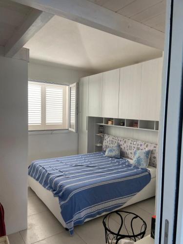 a bedroom with a large bed with a blue comforter at Casa Isabell Con Piscina Privata in San Teodoro