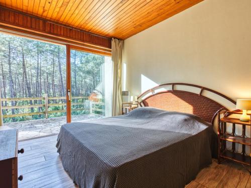 une chambre avec un lit et une grande fenêtre dans l'établissement Holiday Home Le Hameau du Point du Jour by Interhome, à Lacanau