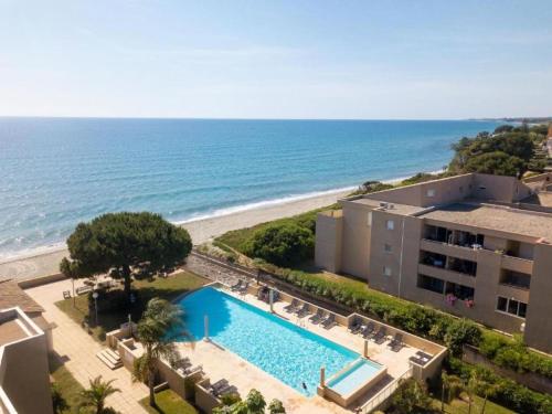 une vue aérienne d'un complexe hôtelier avec piscine et plage dans l'établissement Apartment MB2 sans vue mer by Interhome, à Moriani-Plage