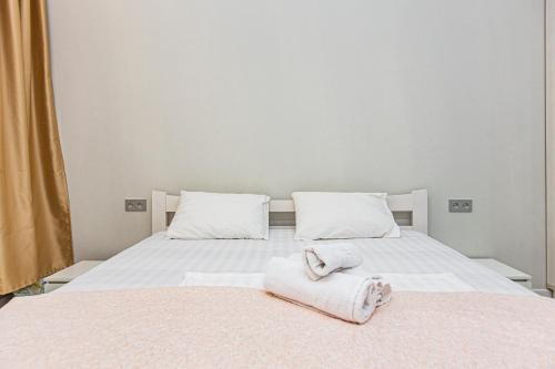 una camera da letto con due asciugamani su un letto bianco di Евро двушка в центре города kv9 a Almaty