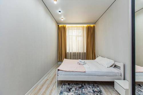 una piccola camera da letto con un letto e una finestra di Евро двушка в центре города kv9 a Almaty