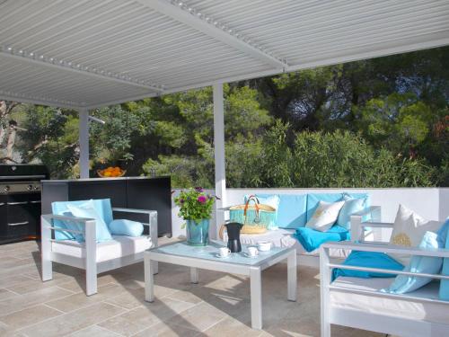 eine Terrasse mit blauen und weißen Möbeln unter einer weißen Pergola in der Unterkunft Holiday Home Nelli by Interhome in Calpe