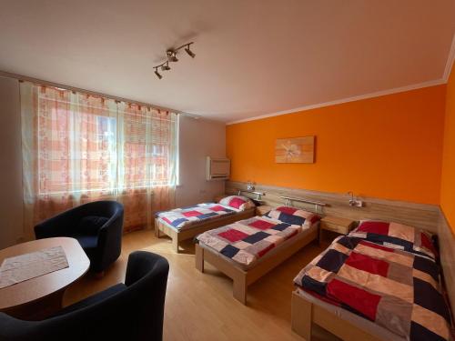 a room with two beds and a table at Dobre ubytovanie in Piešťany
