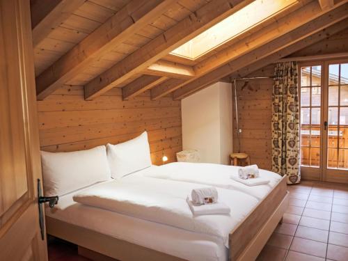 a bedroom with a large white bed in a attic at Apartment Chalet Pfingstrose by Interhome in Grindelwald